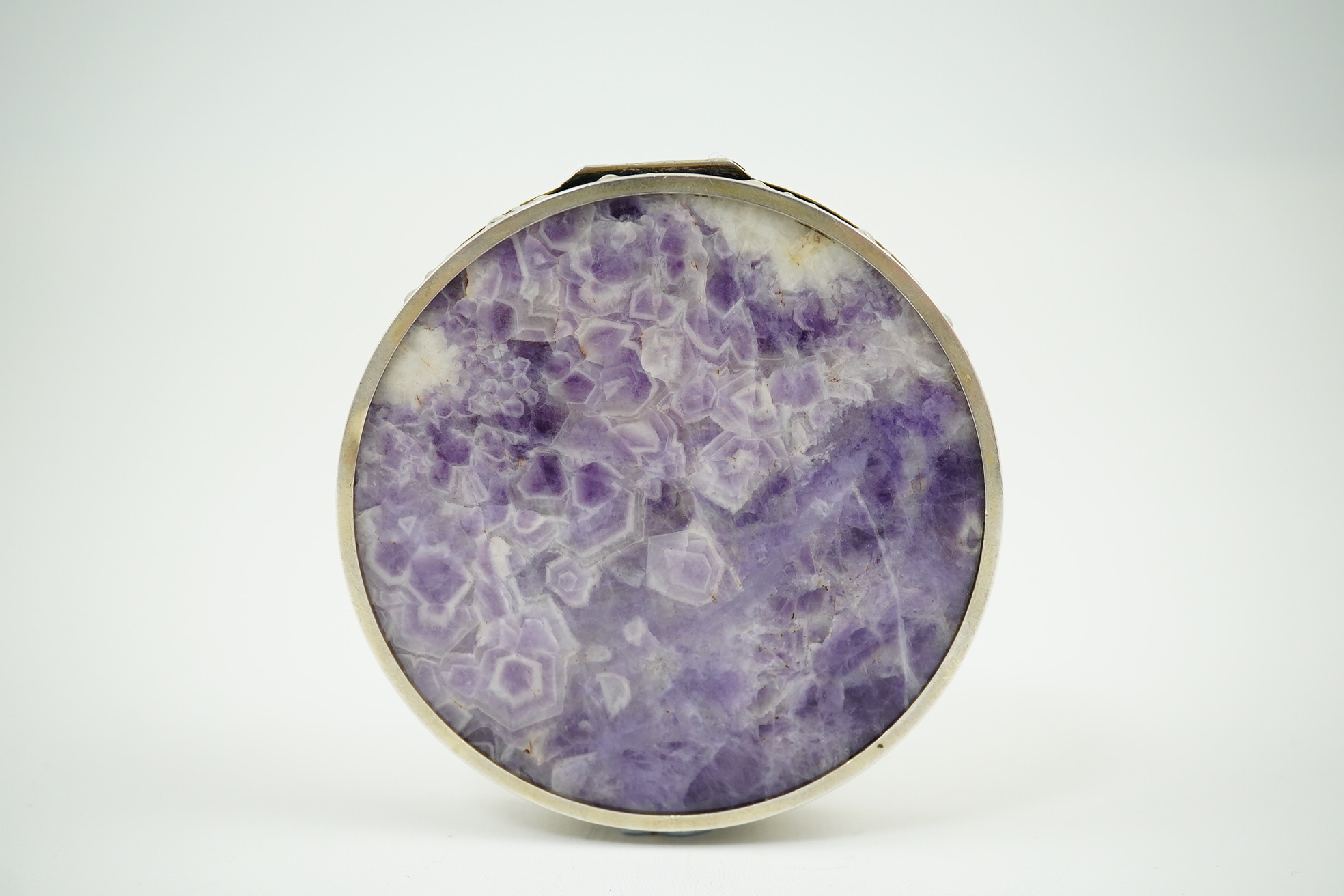 An early 20th century pierced parcel gilt silver mounted amethyst circular box and cover